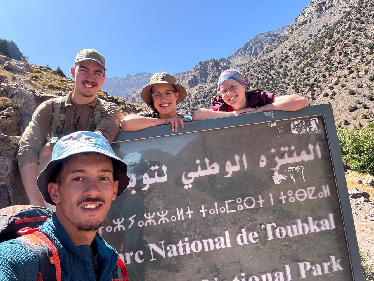 Local Amazigh mountain guide interacting with trekkers during the Morocco Mount Toubkal trek in the High Atlas Mountains