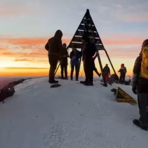 "Amazigh guide instructing trekkers on Mount Toubkal trail "Amazigh guide instructing trekkers on Mount Toubkal trail