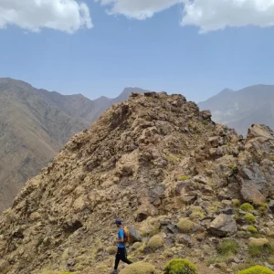 Upper slopes of Mount Toubkal at dawn with hikers ascending toward the summit during the second day of the 2 day trek Upper slopes of Mount Toubkal at dawn with hikers ascending toward the summit during the second day of the 2 day trek