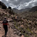 Local guide walking through the Atlas Mountains Morocco with traditional villages in the High Atlas