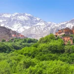 Early morning light in Imlil Valley with terraces, orchards, and traditional stone houses under soft mountain shadows.