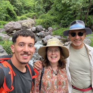 A local guide with visitors during a leisurely stroll among the terraces of the Imlil Valley in Morocco A local guide with visitors during a leisurely stroll among the terraces of the Imlil Valley in Morocco
